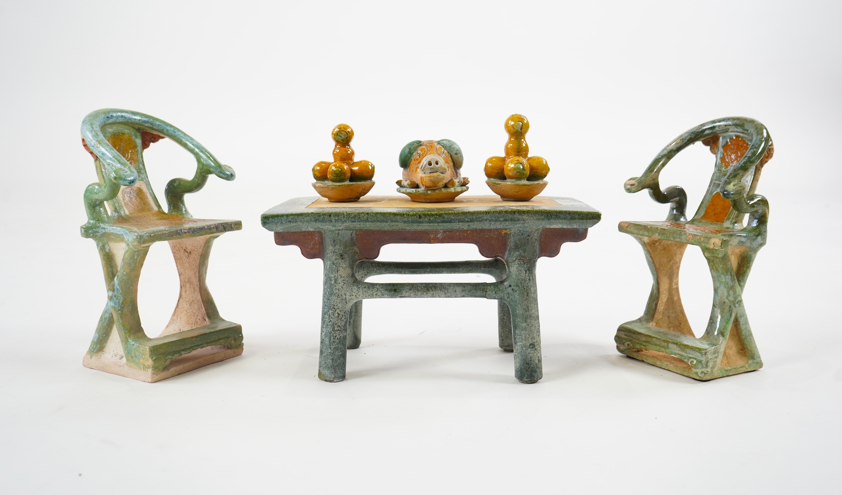 A set of Chinese Ming Sancai models of table with offerings and a pair of horseshoe shaped armchairs, 16th century